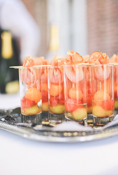 Glaasjes meloen met ham op een zilveren plateau tijdens een receptie