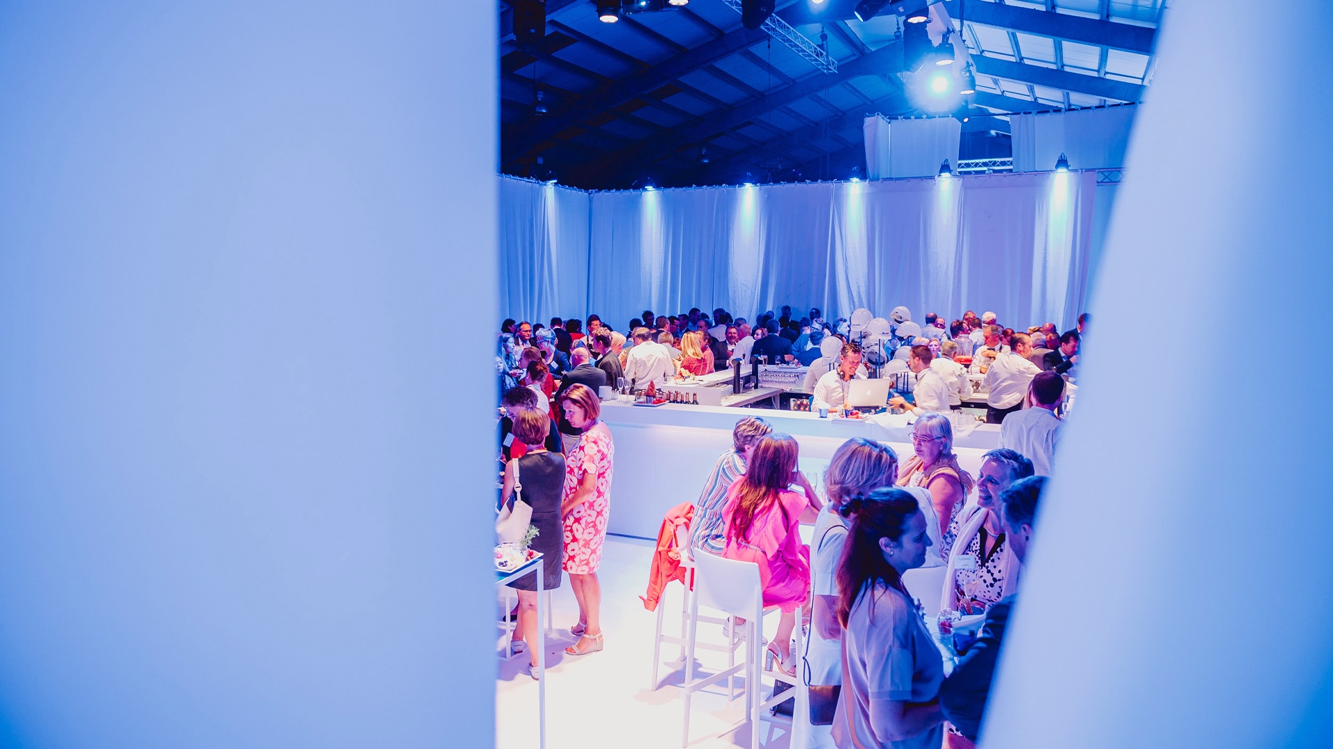 Wit event-decor met een volle bar op een groot bedrijfsevent